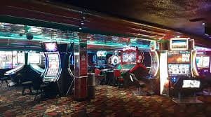 Live Caribbean Stud Poker table on bibit slot with dealer, player positions, and payout table visible